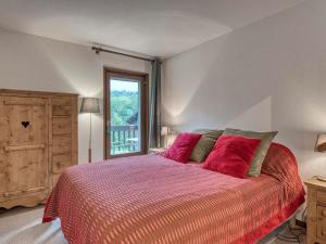 - une chambre avec un lit doté d'oreillers rouges et une fenêtre dans l'établissement Appartement Megève, 3 pièces, 4 personnes - FR-1-453-101, à Megève