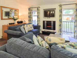 a living room with two couches and a tv at Forest Pines Lodge in Bowness-on-Windermere