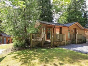 a cabin in the woods with a front porch at Forest Pines Lodge in Bowness-on-Windermere