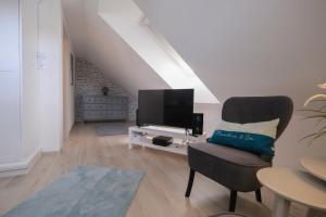 een woonkamer met een stoel en een flatscreen-tv bij Casa alla Torre in Vollersode