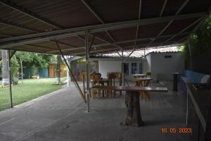 a patio with a table and chairs under a roof at Casa Campestre El Encanto in Trujillo