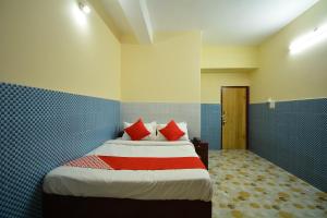 a bedroom with a bed with red pillows at OYO Flagship Hotel Gloria Inn in Agartala