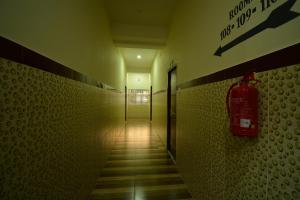 a hallway with a fire extinguisher on the wall at OYO Flagship Hotel Gloria Inn in Agartala