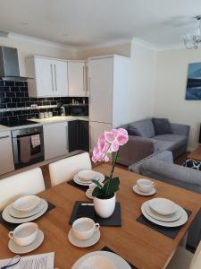 a dining room table with plates and a flower on it at Victoria Quays Apartments, Fleetwood in Fleetwood