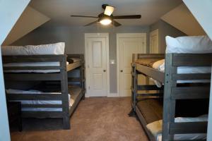 a room with four bunk beds and a ceiling fan at Modern Midtown home with 3 king beds in Memphis