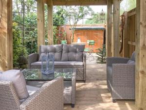 a patio with wicker chairs and a glass table at Beck Cottage in Thirsk