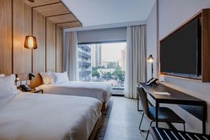 a hotel room with two beds and a flat screen tv at Radisson Pinheiros in São Paulo