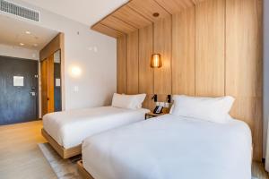 two beds in a room with wooden walls at Radisson Pinheiros in São Paulo