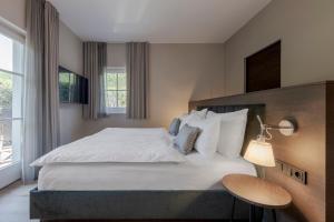 ein Schlafzimmer mit einem großen weißen Bett und einem Fenster in der Unterkunft Hotel Magdalener Hof in Bozen