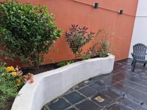 a stone retaining wall with flowers and a chair at Isla Bonita Suites in Ushuaia
