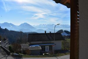 einen Blick auf ein Haus mit Bergen im Hintergrund in der Unterkunft Ferienwohnung in Fraxern