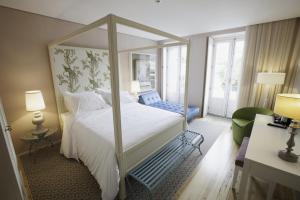 1 dormitorio con 1 cama blanca grande con dosel en In Porto Gallery Guesthouse, en Oporto