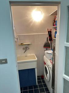 a small kitchen with a sink and a washing machine at La Casa dei Due Aranci in Albisola Superiore