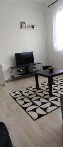 sala de estar con mesa y alfombra blanca y negra en Blue Moon Apartman, en Eger