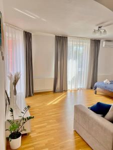 ein Wohnzimmer mit Sofa und Hartholzboden in der Unterkunft Cozy apartment next to the park in Ternopil