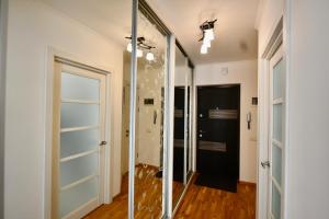 a glass pivot door in a hallway with a glass wall at Cozy apartment next to the park in Ternopilʼ
