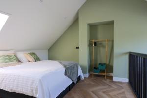 a bedroom with a white bed and a staircase at Erve Mulder vakantiehuis met eigen jacuzzi en eigen sauna in Weerselo