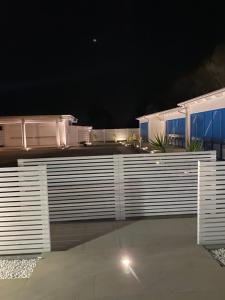 une clôture blanche devant une maison la nuit dans l'établissement GIGLIO DI MARE Residence, à Sellia Marina