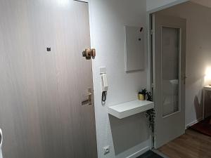 La salle de bains est pourvue d'un lavabo et d'un téléphone mural. dans l'établissement Stylish 1-bedroom flat with beautiful terrace , for a cosy Retreat, à Strasbourg