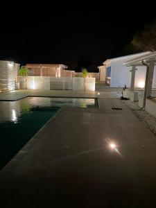 - une piscine la nuit à côté d'une maison dans l'établissement GIGLIO DI MARE Residence, à Sellia Marina