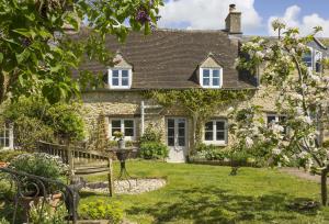 a stone house with a garden in front of it at Mole End Cottage in North Cerney