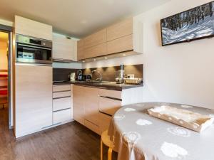 ラ・クリュサにあるStudio cosy au pied des pistes avec terrasse, garage et WIFI - La Clusaz - FR-1-437-66のキッチン(木製キャビネット、テーブル付)