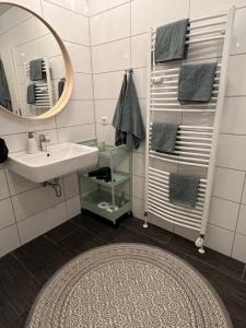 a bathroom with a sink and a mirror and a rug at Fischtown Apartment II in Bremerhaven