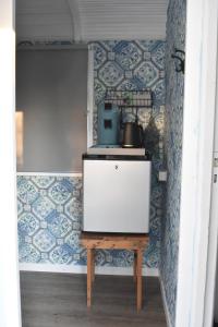 cocina con papel pintado azul y blanco y fogones en Pipowagen ''Slapen by Co'' en Leerdam