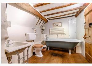 La salle de bains est pourvue d'une baignoire, de toilettes et d'un lavabo. dans l'établissement Mansfield Cottage, à Kilsby