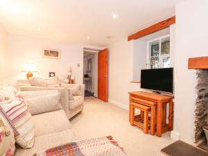 Una sala de estar con un sofá y un televisor. en Yanway Cottage, en Windermere