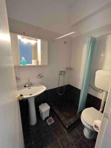 a bathroom with a sink and a toilet and a shower at Cozy studio in Skala, Agistri in Skala