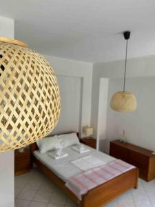 a bedroom with a bed and a wicker lamp at Cozy studio in Skala, Agistri in Skala