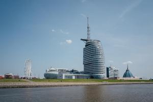 a tall building with a tower on top next to a body of water at Fischtown Apartment II in Bremerhaven