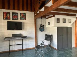 Habitación con teclado, escritorio y guitarra en El Farolito House Bariloche en San Carlos de Bariloche