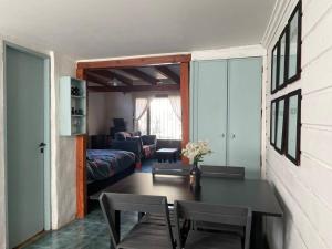 Habitación con mesa, sillas y sala de estar. en El Farolito House Bariloche en San Carlos de Bariloche