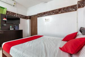 een slaapkamer met een groot bed met rode kussens bij OYO 19396 Cristal Residency in Chennai