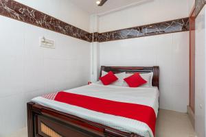 een slaapkamer met een groot bed met rode kussens bij OYO 19396 Cristal Residency in Chennai