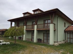 a large green house with a balcony on top at Apartamentos Palacio Bueño in Colunga