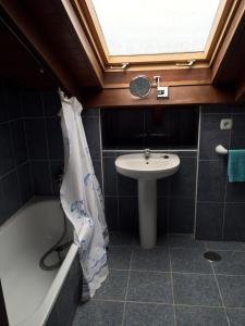a bathroom with a sink and a toilet and a tub and a sink at Apartamentos Palacio Bueño in Colunga +29 photos
