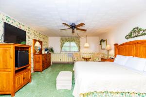 a bedroom with a bed and a flat screen tv at Azalea Garden Inn in Blowing Rock