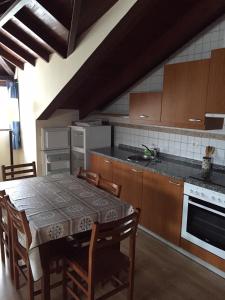 a kitchen with a table and chairs and a kitchen with a stove at Apartamentos Palacio Bueño in Colunga