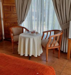 オルムエにあるPueblo Andaluz Olmuéのテーブルと椅子2脚、窓が備わる客室です。