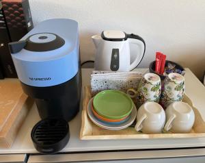 a coffee maker and plates and cups on a counter at Nuova dependance in Rovio