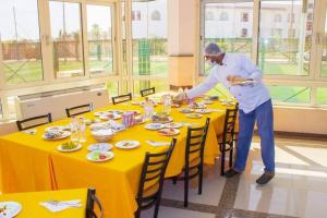 a man standing at a table with a plate of food at بيت الشباب الاسماعيلية - Ismailia Youth Hostel in Ismailia +77 photos