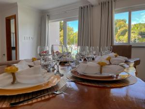 una mesa de comedor con platos y vasos. en 7 Heaven Arraial D'ajuda - SUA CASA EM ARRAIAL - Gileade, en Porto Seguro