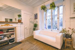 a living room with a white couch and a window at Auberge de la paix in Quebec City