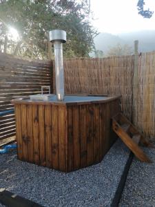 une baignoire en bois avec une fontaine devant une clôture dans l'établissement Trinares de Olmue, à Granizo
