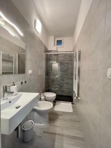 a bathroom with two sinks and a toilet and a shower at Rosaria's Home in Brindisi