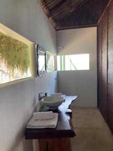 uma casa de banho com 2 lavatórios num balcão de madeira em Isla Única em Isla Grande