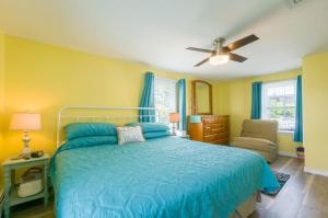 a bedroom with a blue bed and a chair at 34 Dillingham Avenue Sandwich Cape Cod - Aloha in Sandwich
